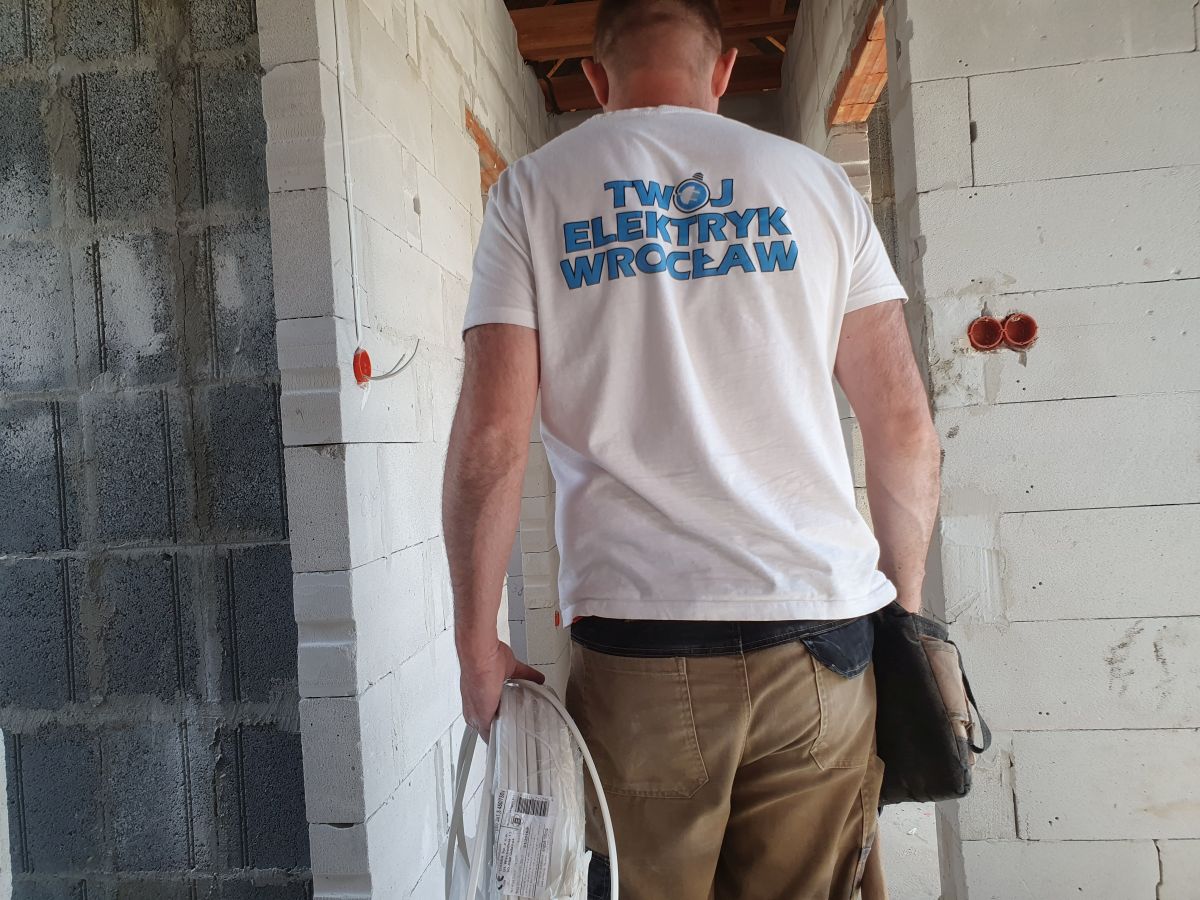 elektryk układa instalację